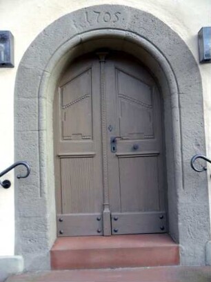 Evangelische Kirche-Langhaus Traufseite Süd-rundbogig gewändete Tür mit Jahr 1705 im Schlußstein (Neubau des Langhauses auf romanisch-gotischem Vorgänger)