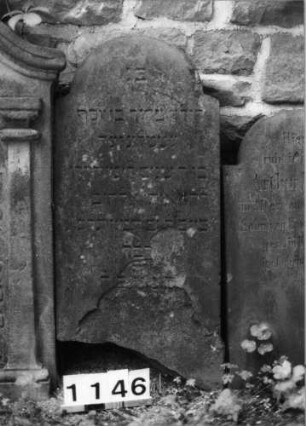 Grabstein 1146 (Index: 99630649) Material: Sandstein Zustand: stark verwittert, abgeblättert, abgebroch. Maße HxBxT: 89x45x5 cm Beschreibung: Stele mit eingezogenem Rundbogenabschluß: Grabstein 1146
