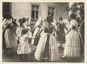 Mark Brandenburg. Oberspreewald bei Vetschau. In sorbische Trachten gekleidete Frauen und Mädchen tanzen vor einem Haus einen Reigen