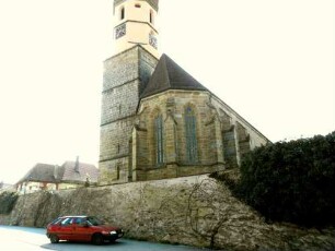 Ansicht von Ostnordosten mit Kirche (über Chor mit Kirchturm im Süden) über fester Kirchhofmauer (Wehrgang mit Steinbrüstung und Schießscharten abgetragen) in Übersicht