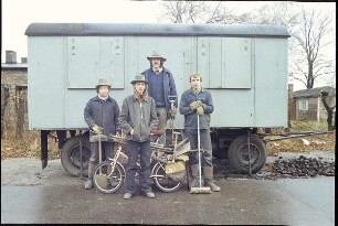 Gruppe von Bauarbeitern vor einem Bauwagen
