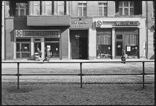 Schönhauser Allee am U-Bahnhof Dimitroffstraße mit Konsum-Filialen "Lebensmittel" und "Wohnkultur"