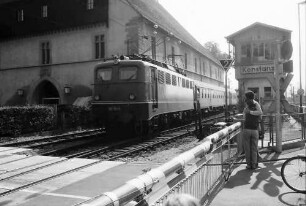 Konstanz: Ausfahrender Zug an Schranke, hinter dem Konzil
