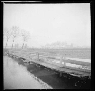 Comines-Warneton (Belgien): Kanal mit Holzbrücke, im Hintergrund eine Kirche [Saint-Chrysole] ("Belgisch-Comines mit Kanal")
