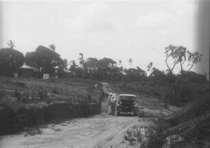 Landschaft bei Mombasa : Blick auf eine Landschaft mit Palmen und einer Straße, auf der ein Automobil steht
