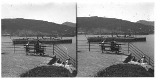 Bergen/ Norwegen: Passagierdampfer Victoria Luise vor der Küste. Touristen auf Parkbänken, Blick vom Ufer auf gegenüberliegende Bucht. Victoria Luise liegt vor der Küste der Stadt Bergen