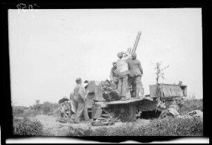 Zwischen Comines (=Comines-Warneton, Belgien) und Messines (=Mesen, Belgien): Soldaten an einer "Feuerstellung der Flakbatterie Bragard (Flak auf Kraftwagen)" beim Blick in den Himmel (Rückansicht, Distanzaufnahme)