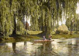 Kanufahrt im Spreewald : Spreewald. Zwei Paddler in einem Kanu auf einem Spreearm oder Fließ, dahinter abgemähte Wiese mit Heuschober