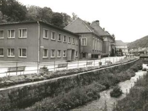 Berggießhübel (Bad Gottleuba-Berggießhübel), Badstraße (Sebastian-Kneipp-Straße) 10. Kneipp-Kurbad (Kulturhaus, um 1930). Straßenansicht von Norden über die Gottleuba auf Verwaltungsbau und Hauptgebäude