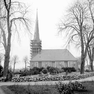 Friedenskirche: Kirchturm mit Baugerüst: Außenansicht von Süden: im Vordergrund Kirchhof: rechts und links Bäume