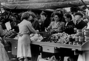 Hamburg-Wandsbek. Nach der Währungsreform. Endlich sind die Stände auf dem Wochenmarkt ordentlich gefüllt. Der Andrang Kaufinteressierter ist Beweis dafür.