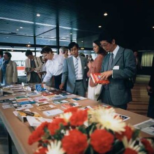 Tagung der Nationalen Forschungs- und Gedenkstätten (NFG) in Berlin 1986, Tagungsgäste an einem Tisch mit internationalen Druckerzeugnissen