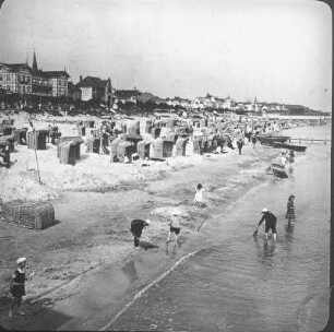 Binz. Strand mit Badegästen und Strandkörben. Blick zur Strandpromenade mit Hotel Kaiserhof (ehem. Kurhaus)