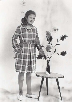 Blumenhocker : Mädchen in kariertem Kleid an einem Nierentischchen mit Blumenvase, aufgenommen im Photo-Atelier/Photo-Handlung Willy Hanisch in Roßwein auf der Gartenstraße 44
