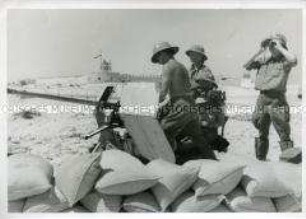 Soldaten beim laden einer Flak. Im Hintergrund Fort Mechili.