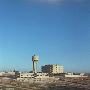 Wasserturm und modernen Wohnblock in einer kargen Landschaft