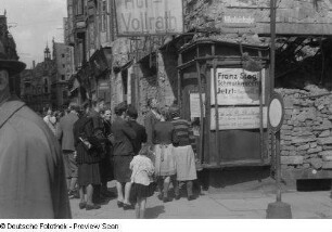 Menschen in der Nikolaistraße vor Plakaten zur Währungsreform