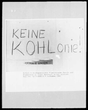 Politische Parole und Plakatrest an einer Hauswand in der Altstadt