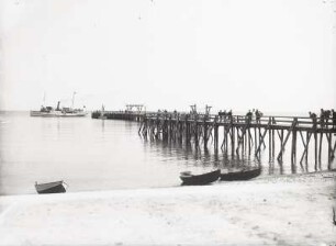 Blick vom Ostseestrand zur Seebrücke mit abfahrendem Dampfer "Kronprinz"