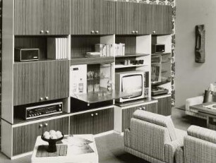 Anbauwand "Poel" : Wohnzimmermöbel. Anbauwand (1974; Möbelkombinat Nord (MKN)). Ansicht mit Sesseln und Couchtisch