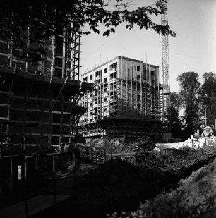 Sülzberg: zwei Wohnblocks mit Gerüsten im Bau: vorn ausgehobene Grube mit Erdhaufen, Baumaterial, Baumaschinen und VW-Käfer: hinten rechts Baukran und Bäume