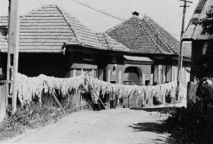 Dorfstraße mit zum Trocknen aufgehängter Wolle