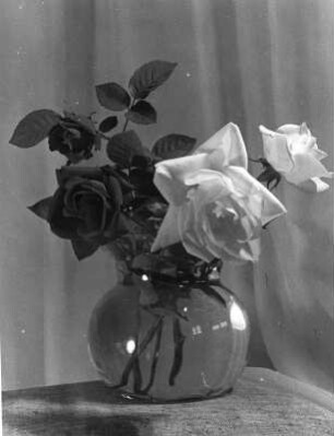 Blumen und Blüten in diversen Vasen. Rosenstrauß in gläserner Kugelvase