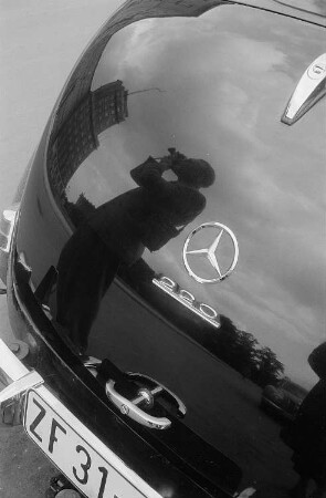 Roger Rössing spiegelt sich beim fotografieren im Heck eines Mercedes