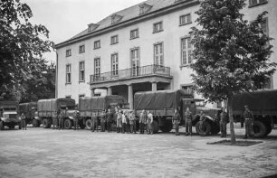 Central Collecting Point Marburg. Transportfahrzeuge der alliierten Truppen vor dem Hessischen Staatsarchiv Marburg.