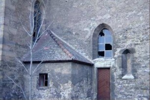 Kirche, Turm Südseite, spitzbogige leere Nische in Außenmauer; kleiner Anbau im Winkel Turm-Langhaus