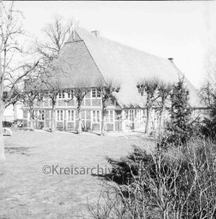 Oetjendorfer Landstraße: Bauerngehöft des Bürgermeisters Erwin Schulz mit Fachwerk: davor Baumreihe: vorn Rasen: rechts Sträucher