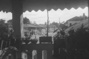 Straßenszene : Blick von einer Veranda in eine Straße.