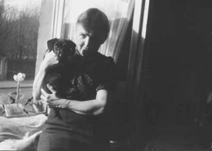 Frau mit Hund vor einem Fenster in Dresden-Laubegast
