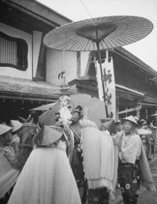 Kind in traditioneller Festkleidung, auf einem Pferd reitend : Tempelfest (O-matsuri), vielleicht Yamabiki Matsuri im August. Kind in traditioneller Festkleidung, auf einem Pferd reitend