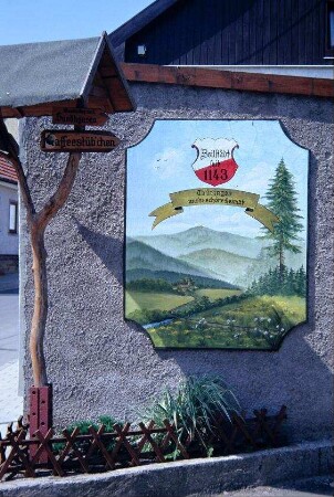 gemalte Tafel an Hauswand und Wegweiser