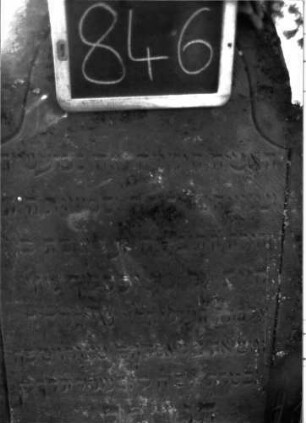 Grabstein 846 (Index: 100102931) Material: Sandstein Zustand: angewittert Maße HxBxT: 104x61x10 cm Beschreibung: Stele, eingezogener Rundbogenabschluss, Schriftfeld durch Rille abgeteilt, mit Konvexbogenabschluss: Grabstein 846 (Detailaufnahme)