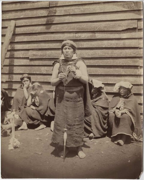 Araucanian woman spinning, behind her women and girls