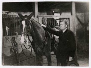 Senator William Borah privat im Stall mit einem Pferd, USA. William Borah
