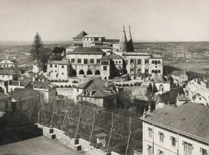 Sintra. Portugal. Ansicht des, im 16. Jahrhundert im Stil der Renaissance errichteten Palácio Nacional de Sintra (Nationalpalastes von Sintra). Im Hintergrund die Atlantikküste. Vorn ein Tennisplatz