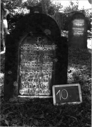 Grabstein 10 (Index: 100101052) Material: Sandstein Zustand: verwittert Maße HxBxT: 83x56x10 cm Beschreibung: Stele, eingezogener Rundbogen, eingetieftes Schriftfeld mit Rundbogen: Grabstein 10