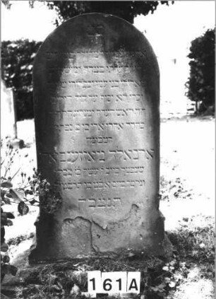 Grabstein 161 (Index: 100085428) Maße HxBxT: 110x55x19 cm Beschreibung: Stele, profi. Sockel, Rundbogenabschl. , Schriftfeld eingetieft m. Spitzbogenabschl.: Grabstein 161A