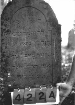 Grabstein 422 (Index: 99800282) Material: Sandstein Zustand: verwittert Maße HxBxT: 105x41x8 cm Beschreibung: Stele, eingezogener Rundbogenabschluß, Schriftfeld eingetieft Besonderheit: Kindergrab: Grabstein 422A