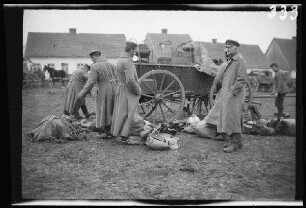 Wirballen (=Virbalis, Litauen): Soldaten und Offiziere und Marschgepäck am Boden vor einem Pferdewagen ("Wagennachschau in Wirballen")