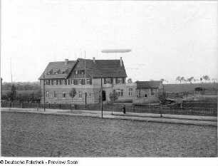 Presse-Heim. Straßenansicht mit Luftschiff vom Typ Zeppelin : Oberwartha. Presse-Heim. Straßenansicht mit Einfriedung und Luftschiff vom Typ Zeppelin