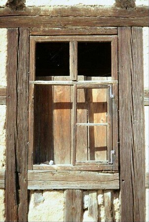 Detail eines Fachwerkhauses: Sprossenfenster ohne Scheiben