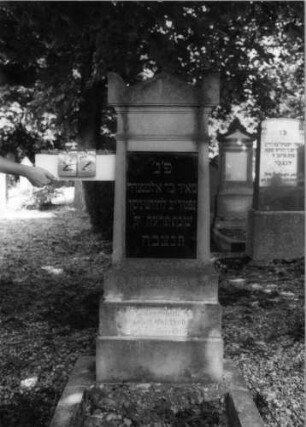 Grabstein 22 (Index: 100086642) Material: Sandstein mit schwarzer Platte Zustand: Sockel leicht verwittert Maße HxBxT: 138x51x23 cm Beschreibung: Stele, getreppter Sockel, Giebel mit Eckakroteren, Schrifttafel rechteckig: Grabstein 22 (1)
