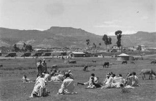 Irreguläre Hilfstruppen bei Adigrat : Irreguläre Hilfstruppen der Italiener bei Adigrat. Eine Gruppe von Personen in einer Savannenlandschaft vor einer Siedlung