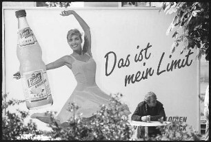 Trinkender Mann vor einer Plakatwand mit der Inschrift "Das ist mein Limit"