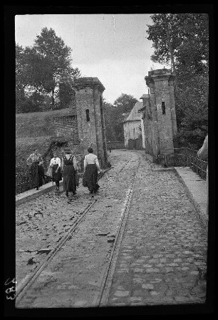 Condè (=Condé-sur-l'Escaut, Dep. Nord, Frankreich): junge Frauen auf der Brücke vor dem "alte[n] Festungstor" (Rückansicht)