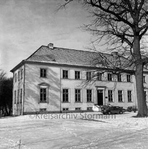 Gut Altfresenburg: das Herrenhaus im Winter: Ansicht der Vorderfront, rechts ein parkender Pkw